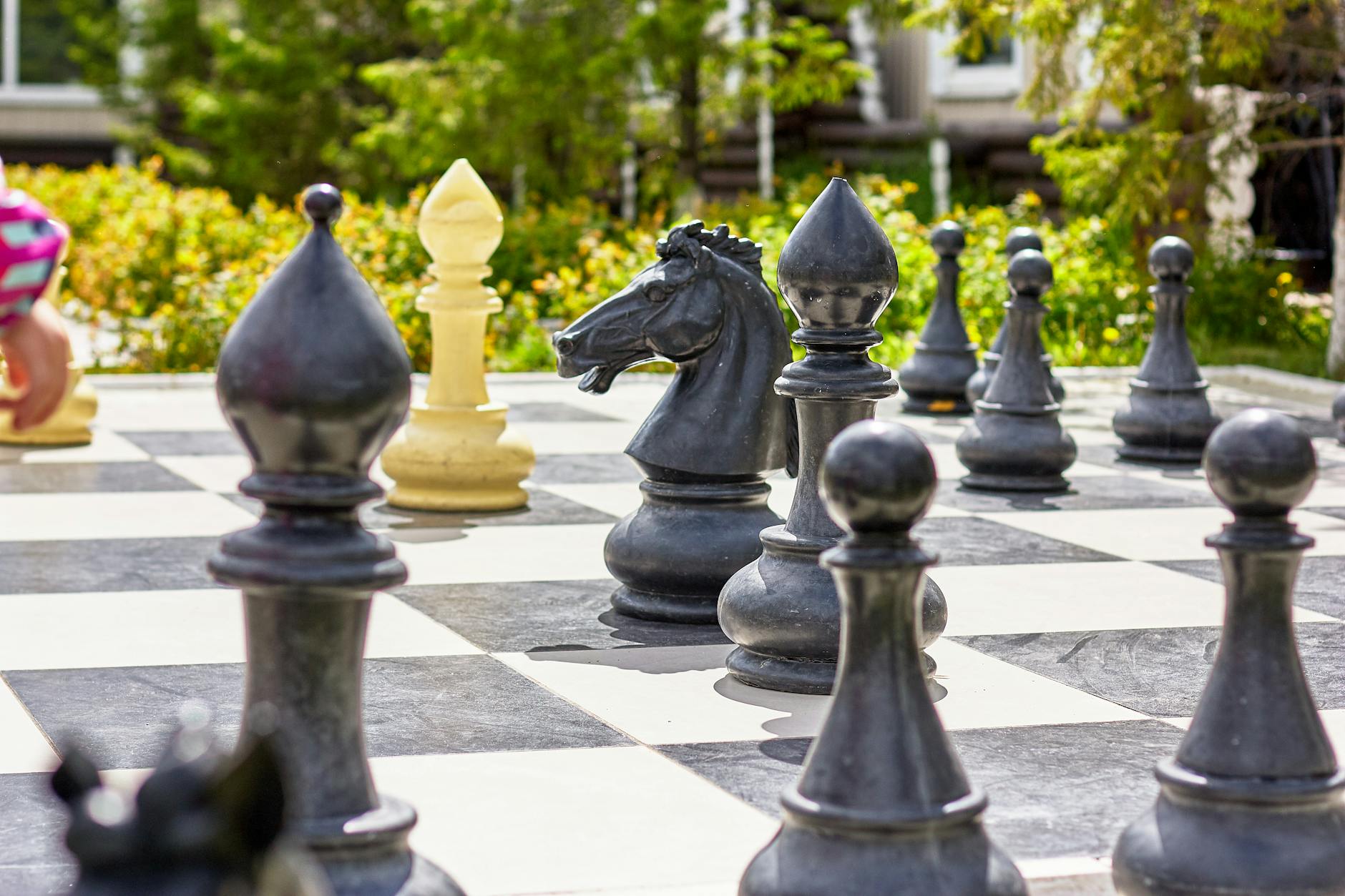 big checkered board with chess pieces in garden
